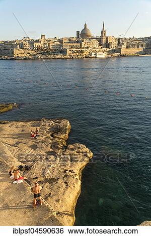 Bathing place on the rocks of Tigne Seafront with city view, Valletta, Malta, Europe View Large Photo Image Stock Photograph - Bathing place on the rocks of Tigne Seafront with city view, Valletta, Malta, Europe. Fotosearch