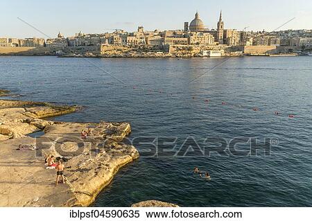 Bathing place on the rocks of Tigne Seafront with city view, Valletta, Malta, Europe View Large Photo Image Stock Photography - Bathing place on the rocks of Tigne Seafront with city view, Valletta, Malta, Europe. Fotosearch