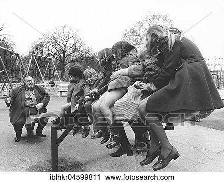 Stock Image - Big man with children on a swing, England, Great Britain. Fotosearch