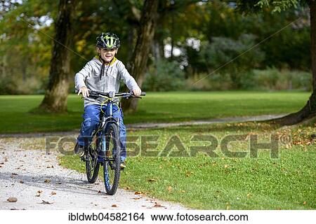 Boy, Child with helmet while riding a bike, Bavaria, Bavaria, Germany, Europe View Large Photo Image Picture - Boy, Child with helmet while riding a bike, Bavaria, Bavaria, Germany, Europe. Fotosearch