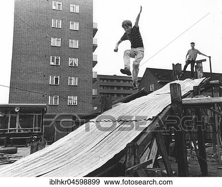 Stock Photo - Boy plays on tin slide, England, Great Britain. Fotosearch