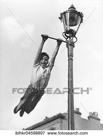 Stock Photo - Boy swings to Lantern, England, Great Britain. Fotosearch