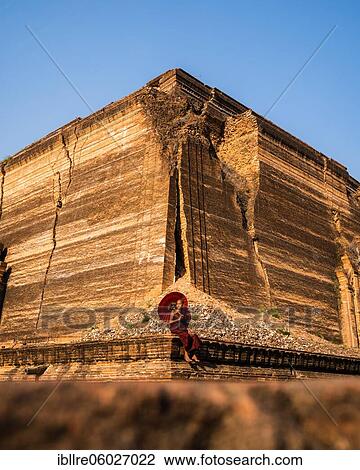 Buddhist monk sitting with red umbrella in front of Mingun Pagoda, Mingun, Myanmar, Asia View Large Photo Image Stock Image - Buddhist monk sitting with red umbrella in front of Mingun Pagoda, Mingun, Myanmar, Asia. Fotosearch