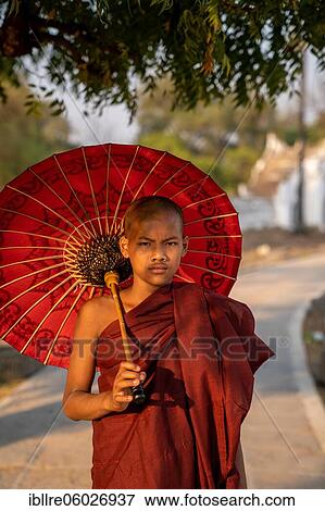 Buddhist monk stands with red umbrella on a path, Mingun, Myanmar, Asia View Large Photo Image Stock Photo - Buddhist monk stands with red umbrella on a path, Mingun, Myanmar, Asia. Fotosearch