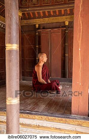 Stock Photography - Buddhist monk with red robe meditating in a pagoda, Shwe Hin Thar Monastery, Sagaing, Myanmar, Asia. Fotosearch