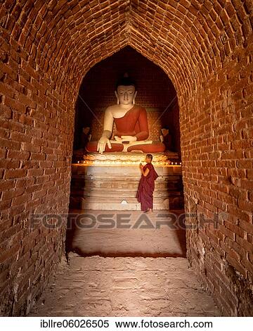 Buddhist young monk in red robe praying standing in a temple, Bagan, Myanmar, Asia View Large Photo Image Stock Photography - Buddhist young monk in red robe praying standing in a temple, Bagan, Myanmar, Asia. Fotosearch