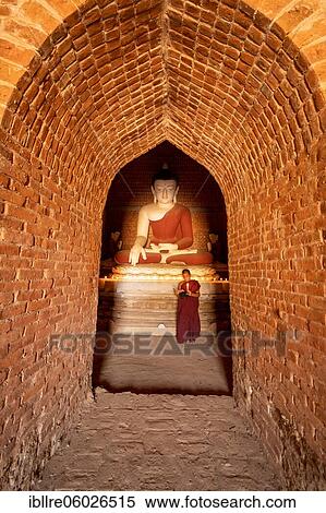 Buddhist young monk in red robe praying standing in a temple, Bagan, Myanmar, Asia View Large Photo Image Stock Photography - Buddhist young monk in red robe praying standing in a temple, Bagan, Myanmar, Asia. Fotosearch