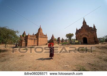 Buddhist young monk in red robe stands with umbrella in front of a temple, Bagan, Myanmar, Asia View Large Photo Image Stock Image - Buddhist young monk in red robe stands with umbrella in front of a temple, Bagan, Myanmar, Asia. Fotosearch