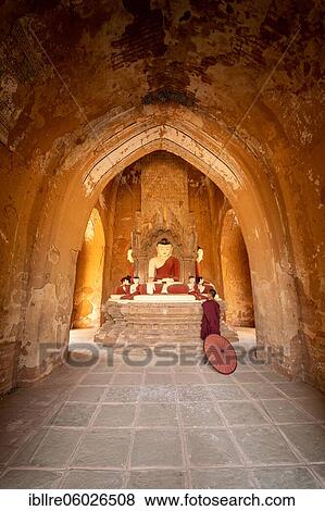 Buddhist young monk in red robe with red umbrella standing in a temple and praying, Bagan, Myanmar, Asia View Large Photo Image Stock Photo - Buddhist young monk in red robe with red umbrella standing in a temple and praying, Bagan, Myanmar, Asia. Fotosearch