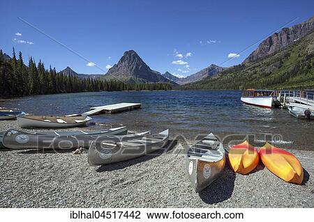 Stock Image - Canoes on the shore of Two Medicine Lake, Sinopah Mountain at back, Glacier National Park, Montana, USA, North America. Fotosearch