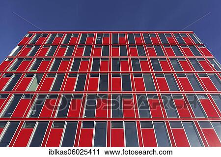 Stock Image - Capricorn office building, red façade, blue sky, Uniper headquarters, Media Harbour Düsseldorf, North Rhine-Westphalia, Germany, Europe. Fotosearch