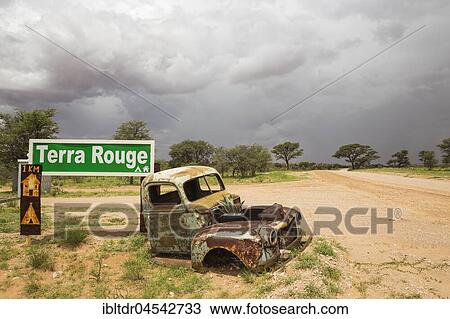 Car wreck at the entrance gate of Terra Rouge guest farm, rainy season with green vegetation, C 15 gravel road, Kalahari Desert, Hardap Region, Namibia, Africa View Large Photo Image Stock Image - Car wreck at the entrance gate of Terra Rouge guest farm, rainy season with green vegetation, C 15 gravel road, Kalahari Desert, Hardap Region, Namibia, Africa. Fotosearch