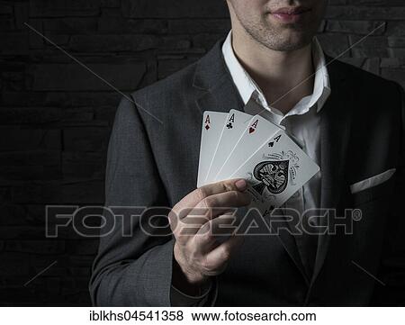 Stock Photo - Card artist Jeremy Rowe holds playing cards in his hand, four aces, Germany, Europe. Fotosearch