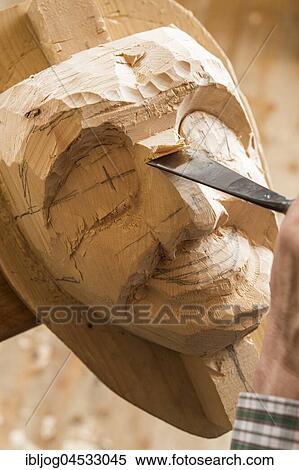 Stock Photography - Carving the face of a wooden mask into wooden block using wood carving tools, wooden mask carver, Bad Aussee, Styria, Austria, Europe. Fotosearch