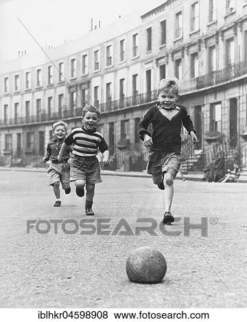 Children play football on the street, 50s, England, Great Britain View Large Photo Image Stock Photo - Children play football on the street, 50s, England, Great Britain. Fotosearch