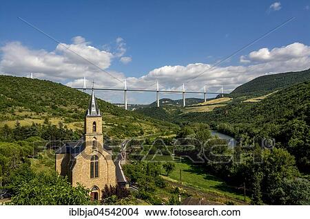 Church of Peyre, Millau viaduct over Tarn river at back, architect Norman Foster, Aveyron, Occitanie, France, Europe View Large Photo Image Picture - Church of Peyre, Millau viaduct over Tarn river at back, architect Norman Foster, Aveyron, Occitanie, France, Europe. Fotosearch