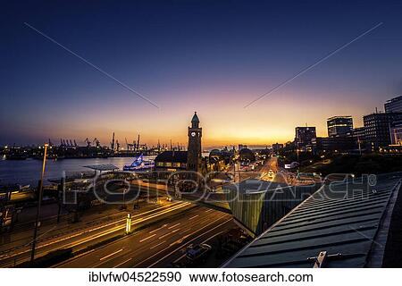 Stock Image - Clock Tower, Gauging tower, St. Pauli landing stages with harbor at sunset, evening red, landing stages, Elbe, St. Pauli, Hamburg, Germany, Europe. Fotosearch