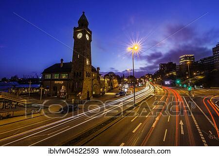 Stock Image - Clock tower, Gauging tower, St. Pauli landing stages with street, night shot, landing stages, harbor, St. Pauli, Hamburg, Germany, Europe. Fotosearch