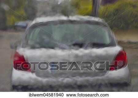 Stock Image - Cloudburst, driving in heavy rain, view through windshield to driving ahead car, Germany, Europe. Fotosearch
