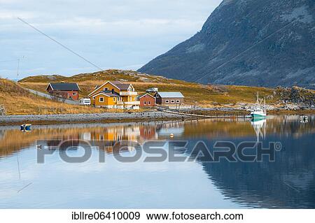 Stock Photo - Colorful houses and sailboat mirrored in the lake with autumn vegetation, Repvag, Finnmark, Norway, Europe. Fotosearch