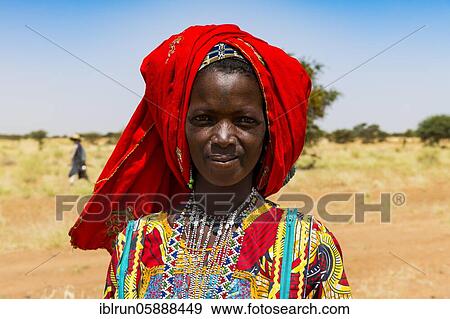 Colourful dressed woman travels with a caravan of Peul nomads and their animals in the Sahel of Niger View Large Photo Image Stock Photo - Colourful dressed woman travels with a caravan of Peul nomads and their animals in the Sahel of Niger. Fotosearch