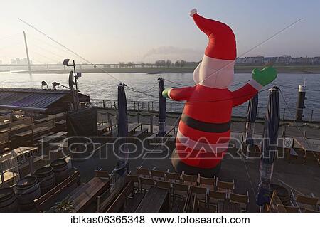 Corona-Lockdown, closed terrace restaurant with waving Santa Claus, Rhine bank, Düsseldorf Old Town, Düsseldorf, North Rhine-Westphalia, Germany, Europe View Large Photo Image Stock Photo - Corona-Lockdown, closed terrace restaurant with waving Santa Claus, Rhine bank, Düsseldorf Old Town, Düsseldorf, North Rhine-Westphalia, Germany, Europe. Fotosearch
