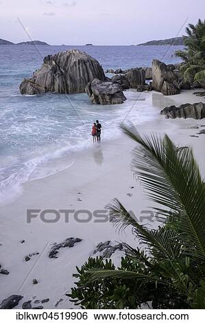 Stock Photograph - Couple at the beach, La Digue, Indian Ocean, Seychelles, Africa. Fotosearch