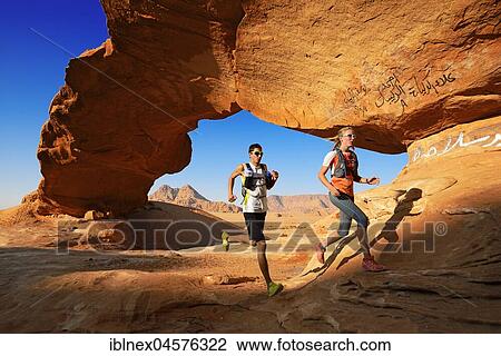 Couple trail running at Rock-Arch named Al Kharza, Wadi Rum, Jordan, Asia View Large Photo Image Stock Image - Couple trail running at Rock-Arch named Al Kharza, Wadi Rum, Jordan, Asia. Fotosearch