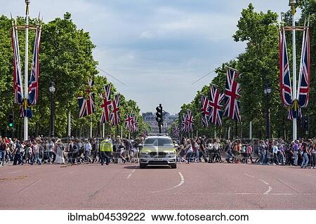 Stock Image - Crowd, tourists crossing street The Mall, City of Westminster, London, England, United Kingdom, Europe. Fotosearch