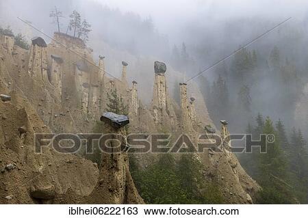 Stock Image - Earth pyramids near Perchau in the mist, South Tyrol, Italy, Europe. Fotosearch