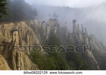 Stock Photo - Earth pyramids near Perchau in the mist, South Tyrol, Italy, Europe. Fotosearch