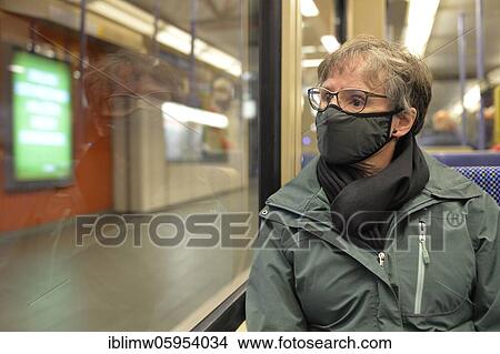 Picture - Elderly woman wearing a face mask, sitting in the subway, corona crisis, Stuttgart, Baden-Württemberg, Germany, Europe. Fotosearch