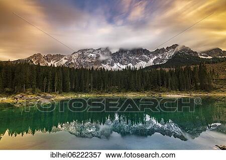 Stock Photo - Evening mood at Lake Carezza, reflection of the Latemar in the water, South Tyrol, Italy, Europe. Fotosearch