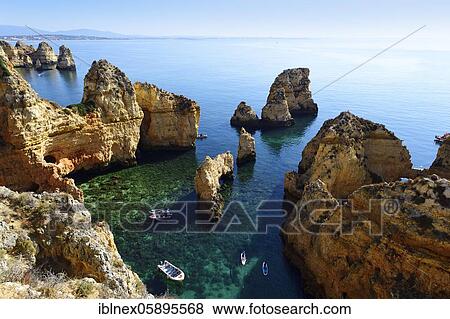 Stock Photo - Excursion boats and SUP boarders in the bay of Ponta da Piedade, Lagos, Algarve, Portugal, Europe. Fotosearch