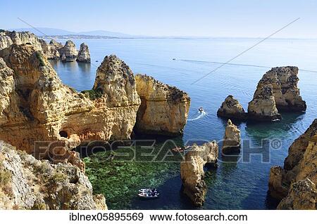 Stock Photo - Excursion boats and SUP boarders in the bay of Ponta da Piedade, Lagos, Algarve, Portugal, Europe. Fotosearch