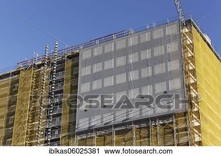 Stock Image - Facade with scaffolding and yellow cladding, building refurbishment, Düsseldorf, North Rhine-Westphalia, Germany, Europe. Fotosearch
