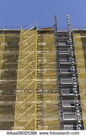 Facade with scaffolding and yellow cladding, building refurbishment, Düsseldorf, North Rhine-Westphalia, Germany, Europe View Large Photo Image Stock Photo - Facade with scaffolding and yellow cladding, building refurbishment, Düsseldorf, North Rhine-Westphalia, Germany, Europe. Fotosearch