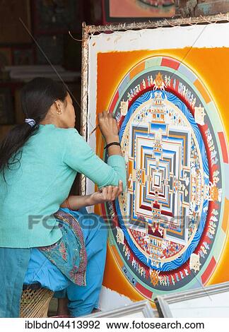 Stock Image - Female artist working on a mandala in a local handicraft shop, near Bhaktapur, Nepal, Asia. Fotosearch