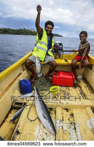 Stock Image - Fisherman in a boat while fishing, off Ambrym Island, South Seas, Vanuatu, Oceania. Fotosearch