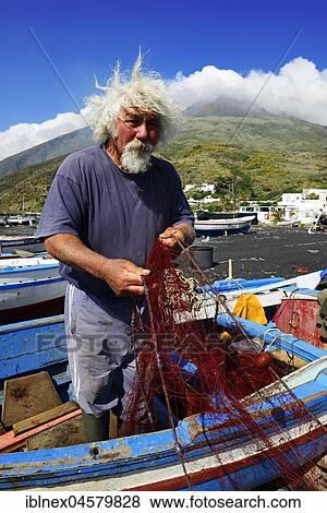 Fishermen repair nets at Scari Beach, in the background of the volcano, Stromboli Island, Lipari Islands, Italy, Europe View Large Photo Image Stock Photo - Fishermen repair nets at Scari Beach, in the background of the volcano, Stromboli Island, Lipari Islands, Italy, Europe. Fotosearch