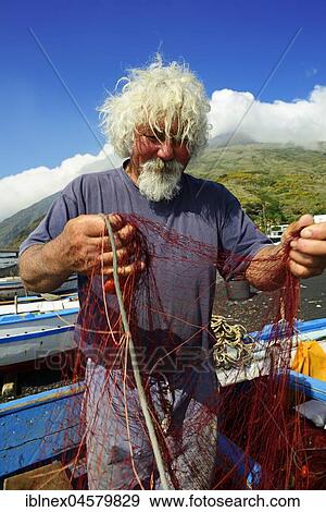 Stock Photo - Fishermen repair nets at Scari Beach, in the background of the volcano, Stromboli Island, Lipari Islands, Italy, Europe. Fotosearch