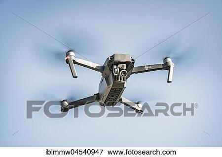 Stock Photo - Flying quadrocopter, remote controlled drone with camera, DJI Mavic. Fotosearch