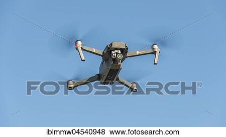 Stock Photo - Flying quadrocopter, remote controlled drone with camera, DJI Mavic. Fotosearch