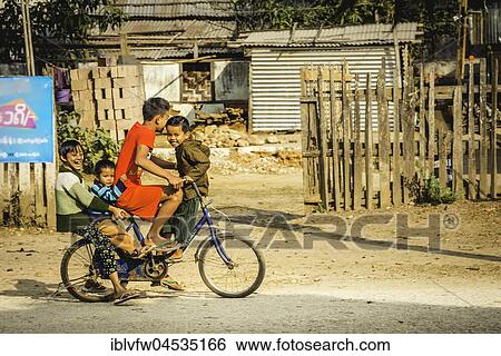 Four indigenous boys laughing together on a bicycle, road scene, Hsipaw, Shan state, Myanmar, Asia View Large Photo Image Stock Photograph - Four indigenous boys laughing together on a bicycle, road scene, Hsipaw, Shan state, Myanmar, Asia. Fotosearch