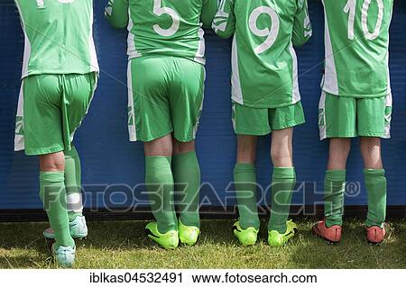 Stock Image - Four players of a youth football team, rear view, North Rhine-Westphalia, Germany, Europe. Fotosearch