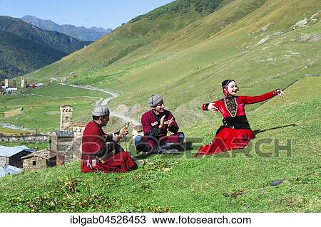 Stock Image - Georgian people of a folkloric group playing Panduri and dancing in traditional Georgian clothes, Ushguli, Svaneti region, Georgia, Asia. Fotosearch