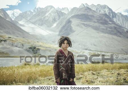 Girl, 8 years old, standing in front of a harvested wheat field, members of the ethnic group of the settled Wakhi, behind them the foothills of the Hindu Kush, Saradh-e-Broghil Wakhan Corridor, Afghanistan, Asia View Large Photo Image Stock Image - Girl, 8 years old, standing in front of a harvested wheat field, members of the ethnic group of the settled Wakhi, behind them the foothills of the Hindu Kush, Saradh-e-Broghil Wakhan Corridor, Afghanistan, Asia. Fotosearch