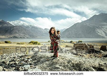 Girl carrying her little brother on her back, members of the ethnic group of sedentary Wakhi, Saradh-e-Broghil, Wakhan Corridor, Afghanistan, Asia View Large Photo Image Stock Photography - Girl carrying her little brother on her back, members of the ethnic group of sedentary Wakhi, Saradh-e-Broghil, Wakhan Corridor, Afghanistan, Asia. Fotosearch