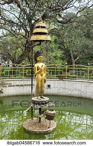 Stock Photograph - Golden statue of Buddha in the World Peace Pond, Swayambunath or Monkey Temple, Unesco World Heritage Site, Kathmandu, Nepal, Asia. Fotosearch