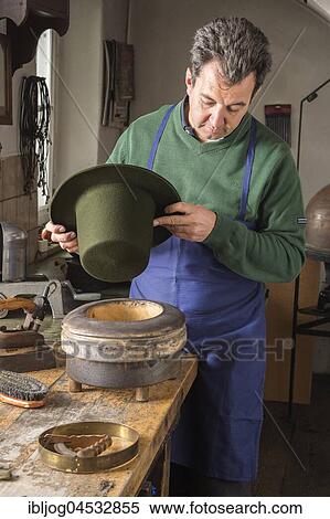 Stock Photography - Hatter holding dry wool felt hat over an edge mold, hatmaker workshop, Bad Aussee, Styria, Austria, Europe. Fotosearch